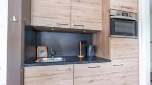 Une cuisine moderne avec des meubles en bois, un évier en acier inoxydable et un four.