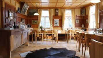 A wooden interior with a large fur rug, wooden furniture, and a bar area.