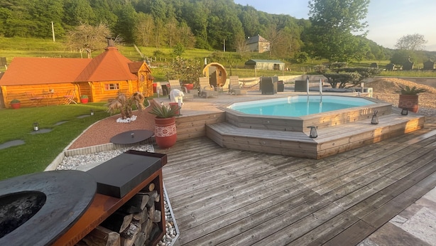 A wooden deck with a hot tub, outdoor furniture, and a pool. - Finnish Kota with Jacuzzi, sauna, heated swimming pool and wellness treatments (Voissant)