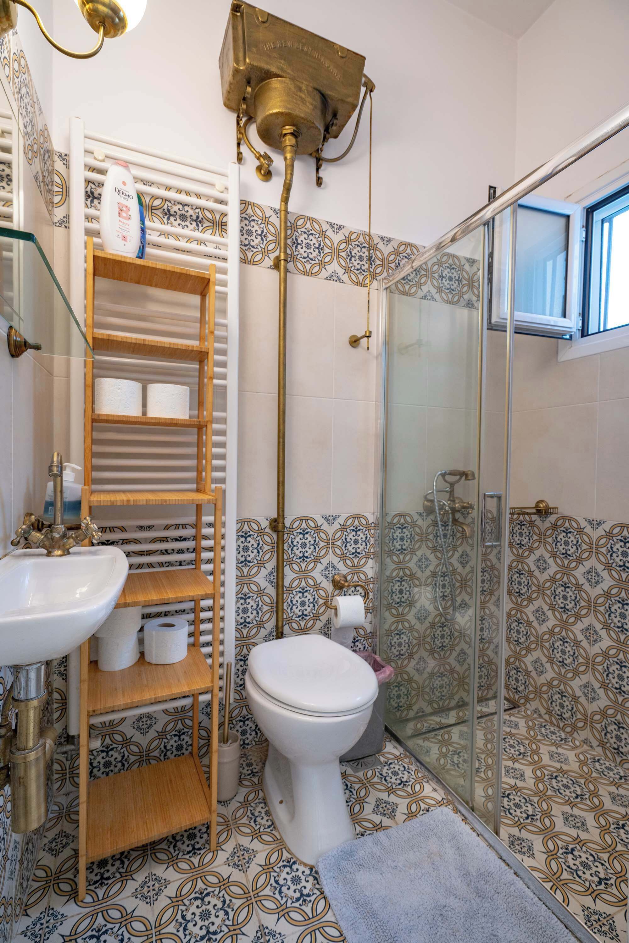 Ein Badezimmer mit Toilette, Waschbecken und Duschkabine aus Glas.