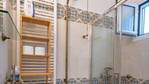 A bathroom with a toilet, sink, and glass shower enclosure. - City Panorama Studio by ΜΡS (Athens)