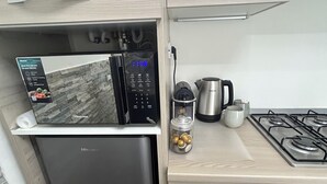 A modern kitchen with a built-in microwave, a stainless steel refrigerator, a gas stove, and a coffee maker. - IRIDE HOME _ Wellness & Relaxation (Bergamo)