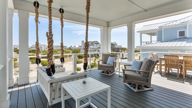 A covered outdoor deck with seating, a table, and rope swings. - Steps to the Beach: 6BR Gem / Ocean Views / BHI + Shoals Club / 2 Carts (Bald Head Island)