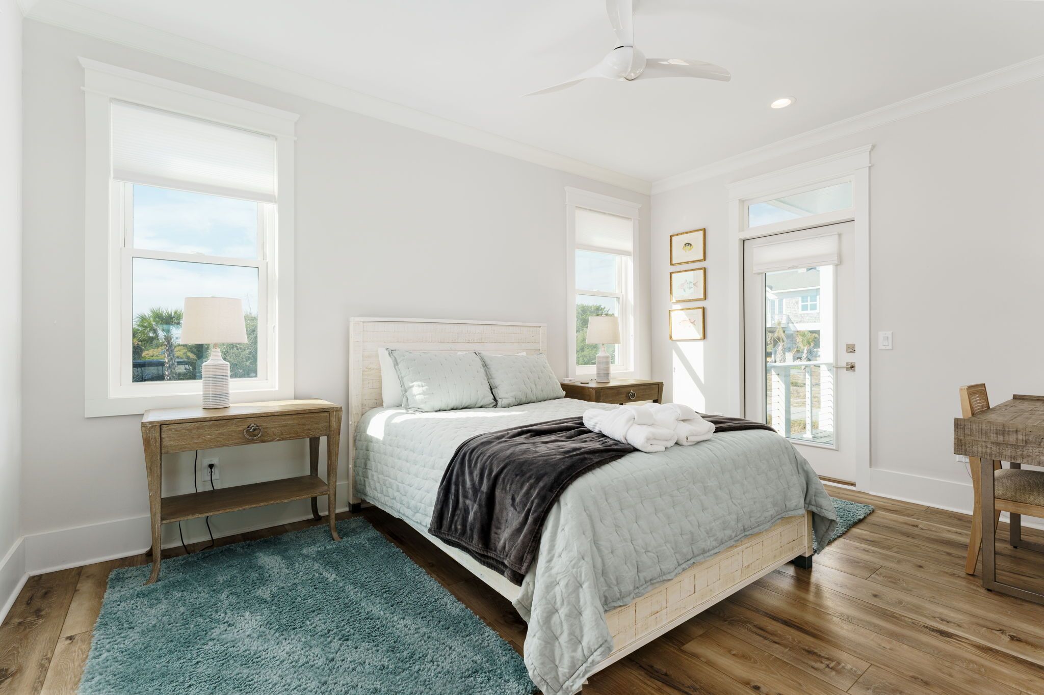 A bedroom with a bed, bedside tables, a desk, and a chair.