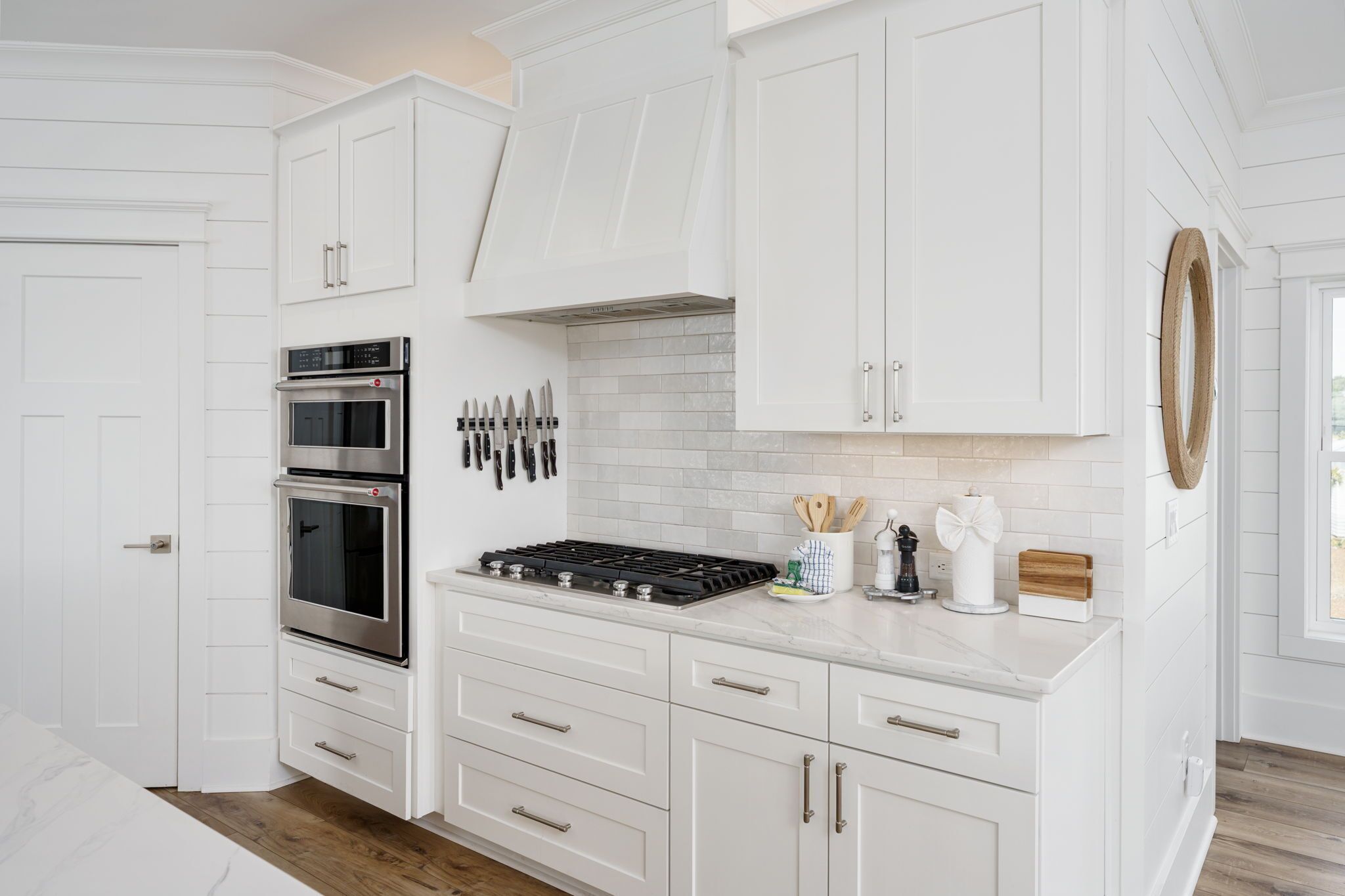 A modern kitchen with white cabinetry, stainless steel appliances, and a tiled backsplash.