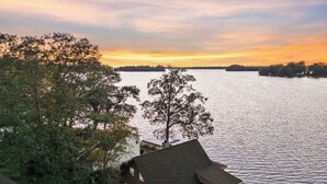 A house with a large window overlooking a lake, surrounded by trees. - Lakefront Cottage with Stunning Sunset Views at Indian Lake! (Belle Center)