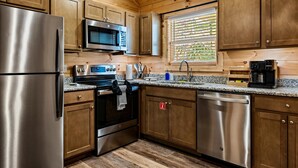 Una cocina moderna con armarios de madera, electrodomésticos de acero inoxidable y una ventana con persianas.