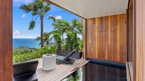 A modern interior with a wooden deck overlooking a scenic ocean view. - Lil' Home (St. Barthelemy)