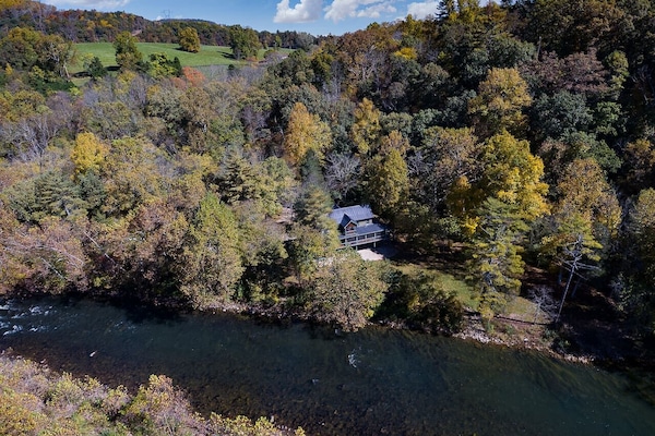 Stunning Aerial View of the Property Nestled Among Lush Green Trees with a Scenic River Beside It