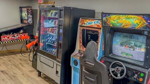 A room with arcade games, including a Donkey Kong machine, and a Monopoly board game.