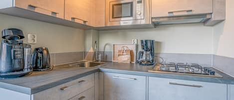 A modern kitchen with stainless steel appliances, a gas stove, and a built-in microwave.