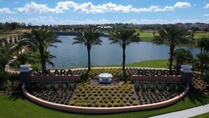 Un resort con un jardín circular, palmeras y vistas a un lago.