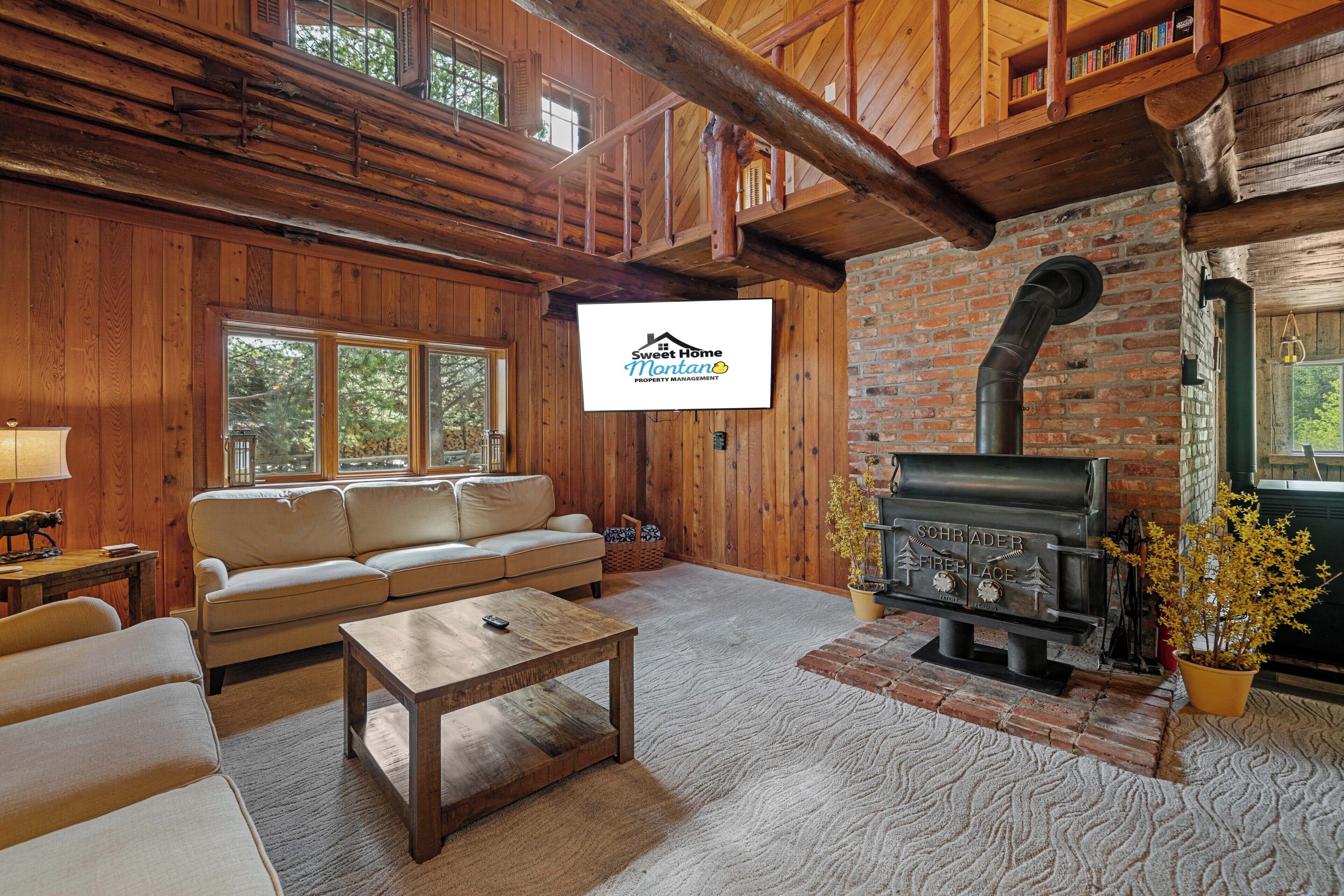 A cozy living room with a sofa, coffee table, fireplace, and a television.