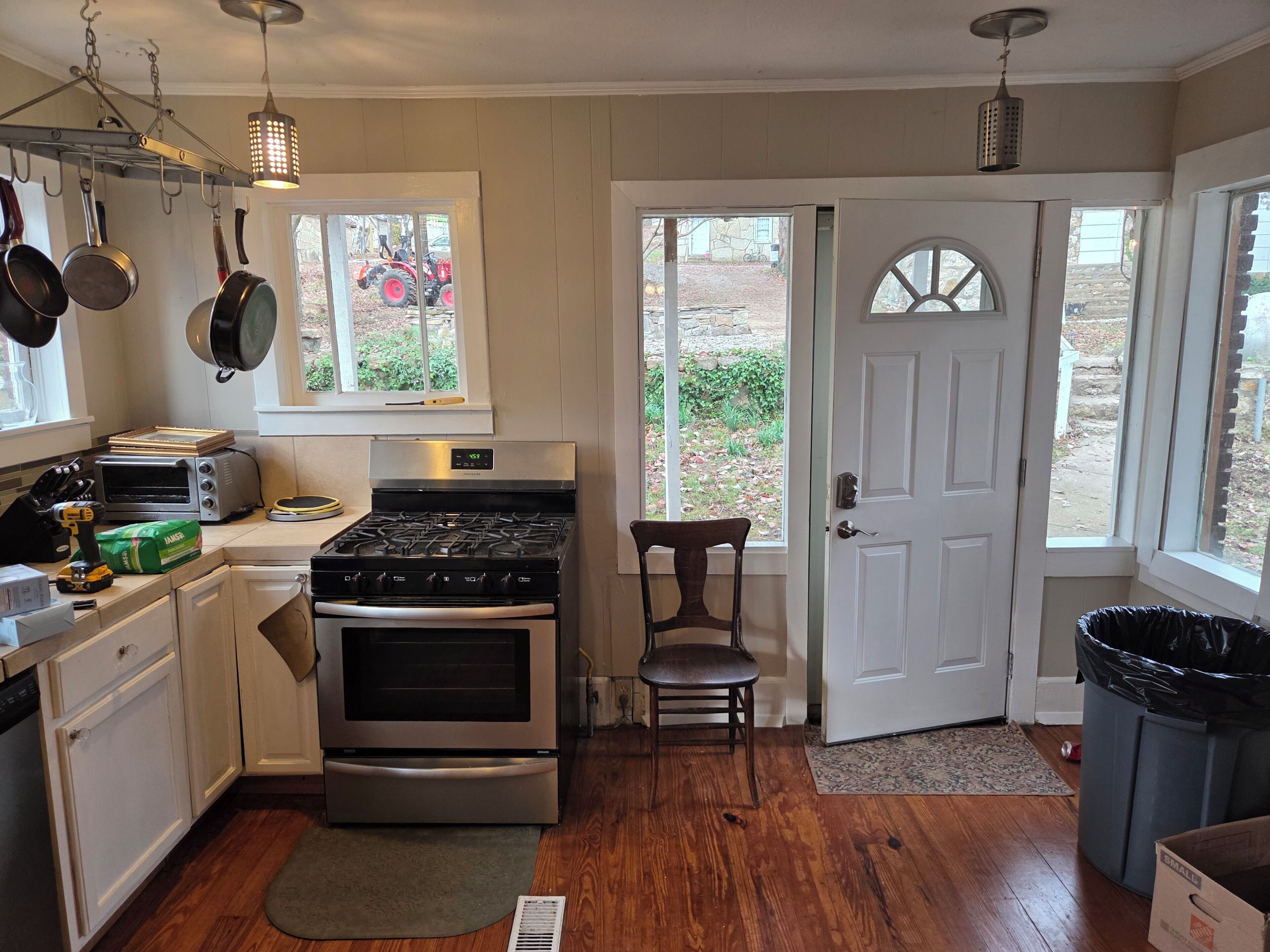A kitchen with a stove, oven, and various utensils.