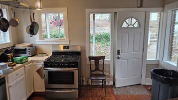 A kitchen with a stove, oven, and various utensils.