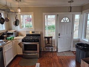 A kitchen with a stove, oven, and various utensils.