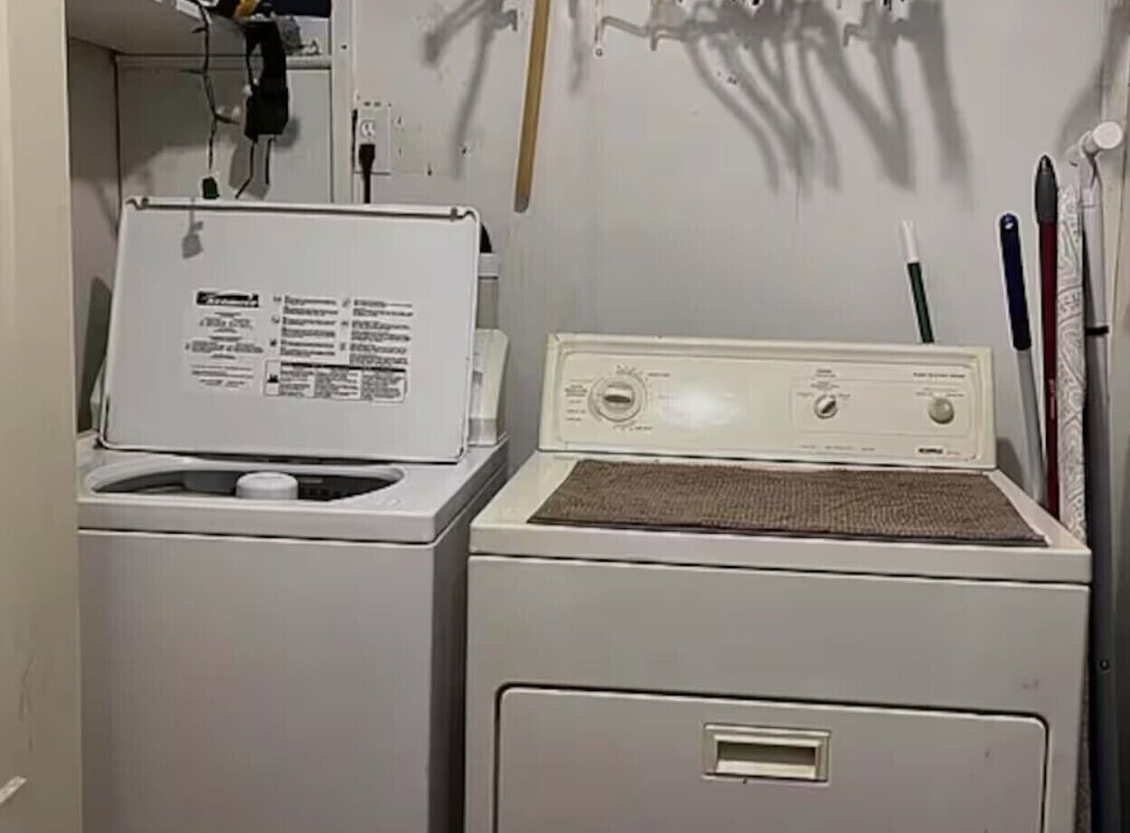 Une buanderie équipée de deux machines à laver et d’un sèche-linge.