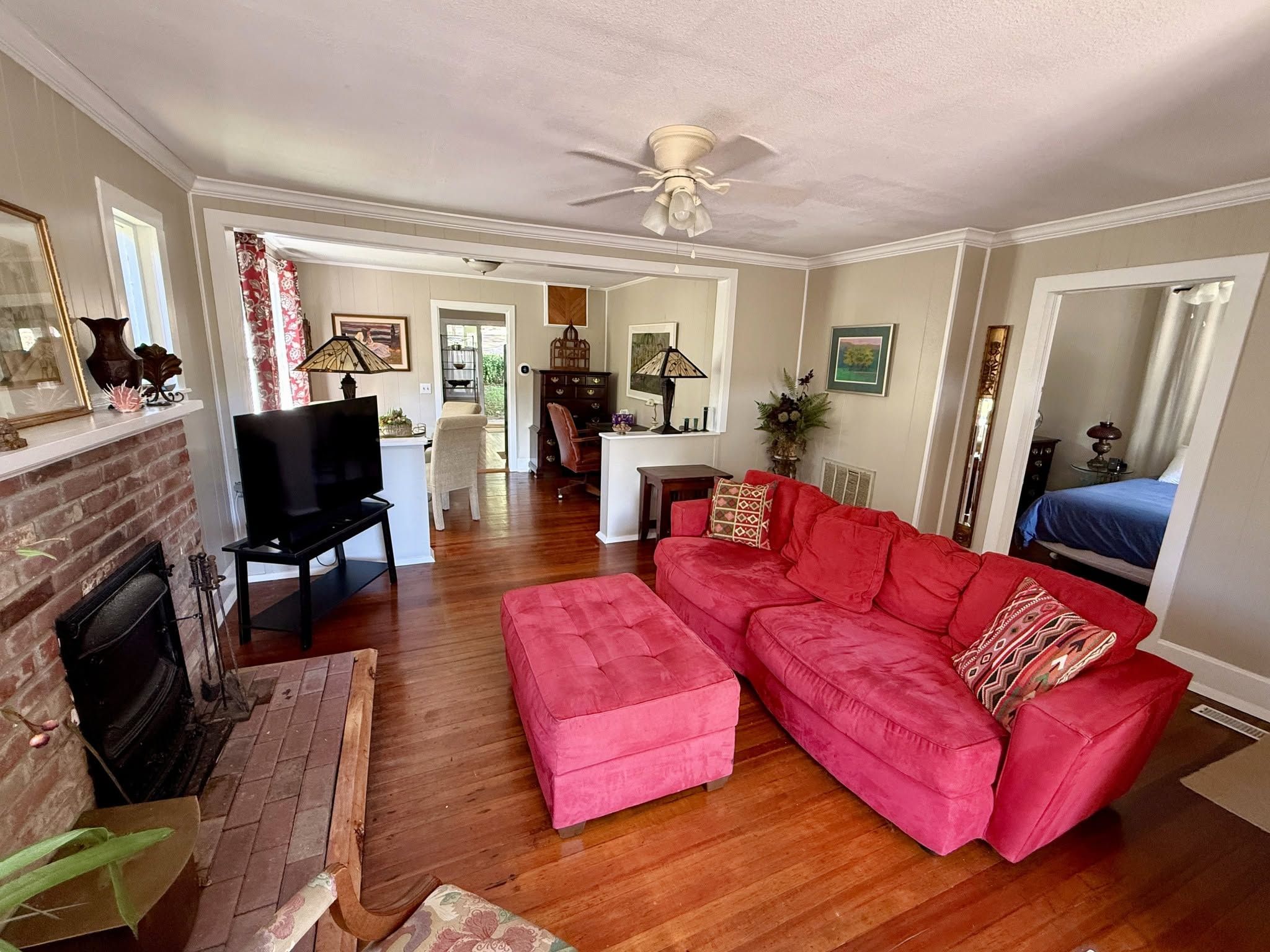 A living room with a red sofa, a television, and a fireplace.