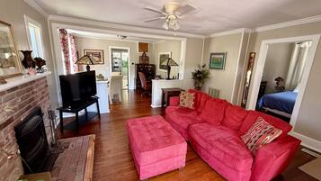 A living room with a red sofa, a television, and a fireplace.
