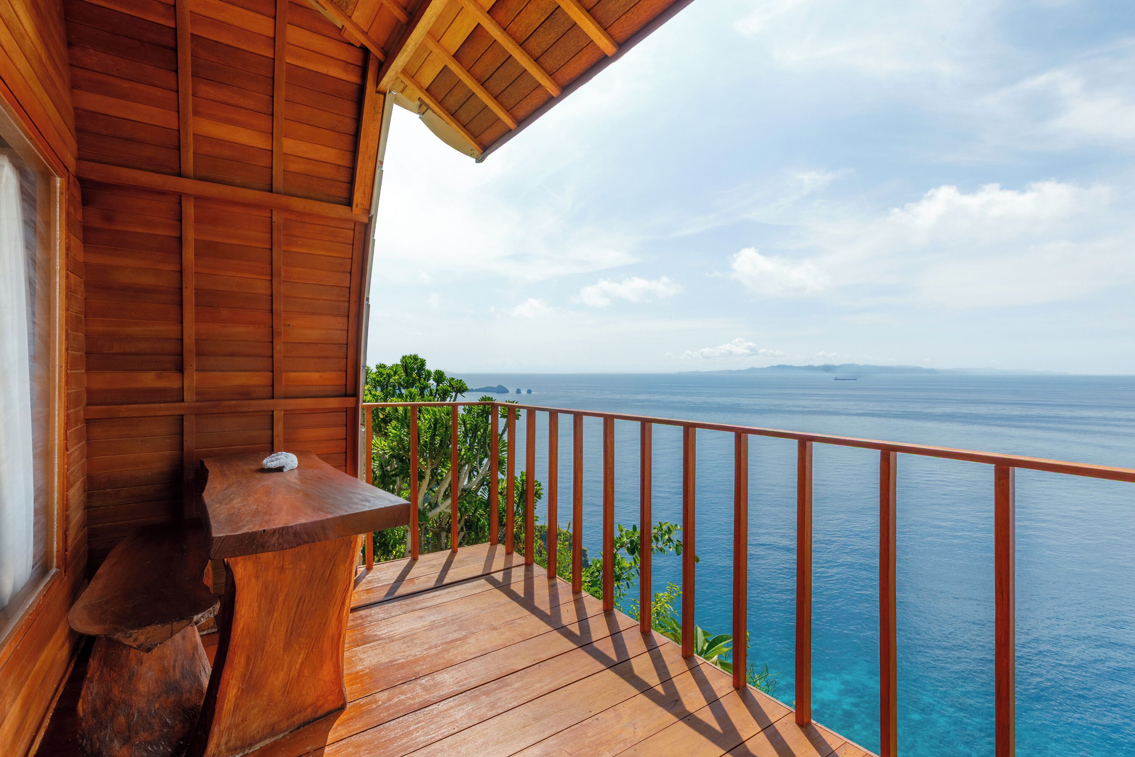 A wooden deck with a railing overlooking a body of water.