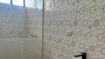 Een douche, handdoeken, zeep, toiletpapier