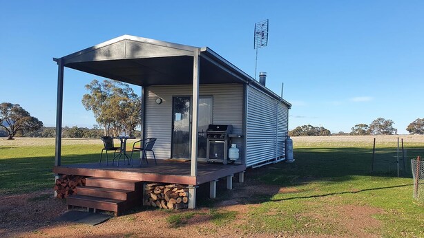Una casa mobile con veranda coperta, barbecue esterno e cortile recintato.