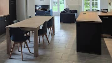 Een moderne keuken met een eetgedeelte, inbouwapparatuur en een groot kookeiland.
