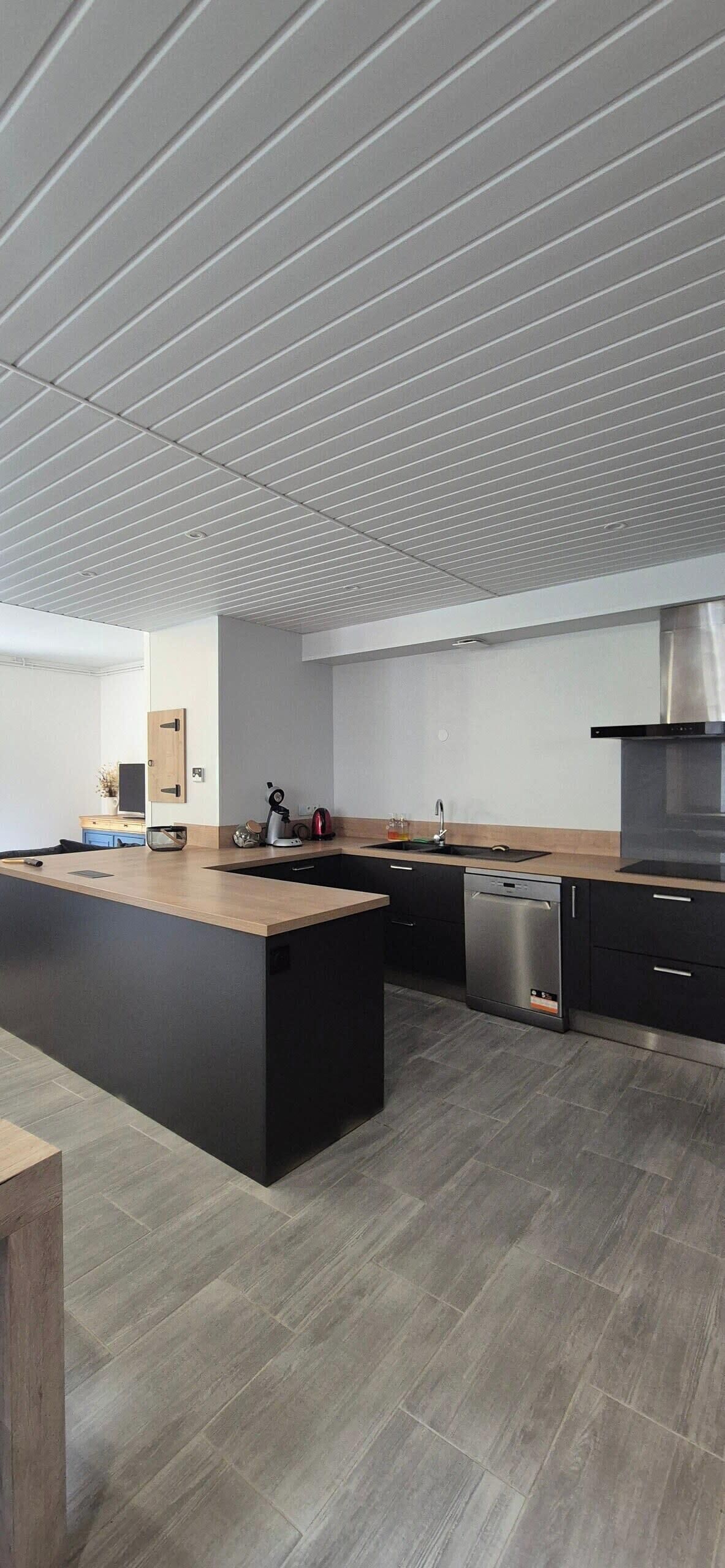 Een moderne keuken met een groot eiland, ingebouwde apparatuur en een strak design.