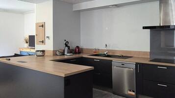 Een moderne keuken met een groot eiland, ingebouwde apparatuur en een strak design.