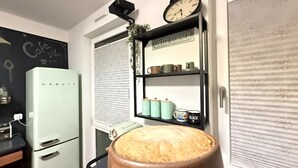 A kitchen with a white refrigerator, a coffee corner with mugs and a clock, and a large pot on the counter. - Fabulous 1-bedroom apartment in Essen (Essen)