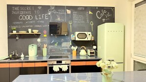 A kitchen with a chalkboard wall listing ingredients to good life, a microwave, toaster, and a green refrigerator. - Fabulous 1-bedroom apartment in Essen (Essen)