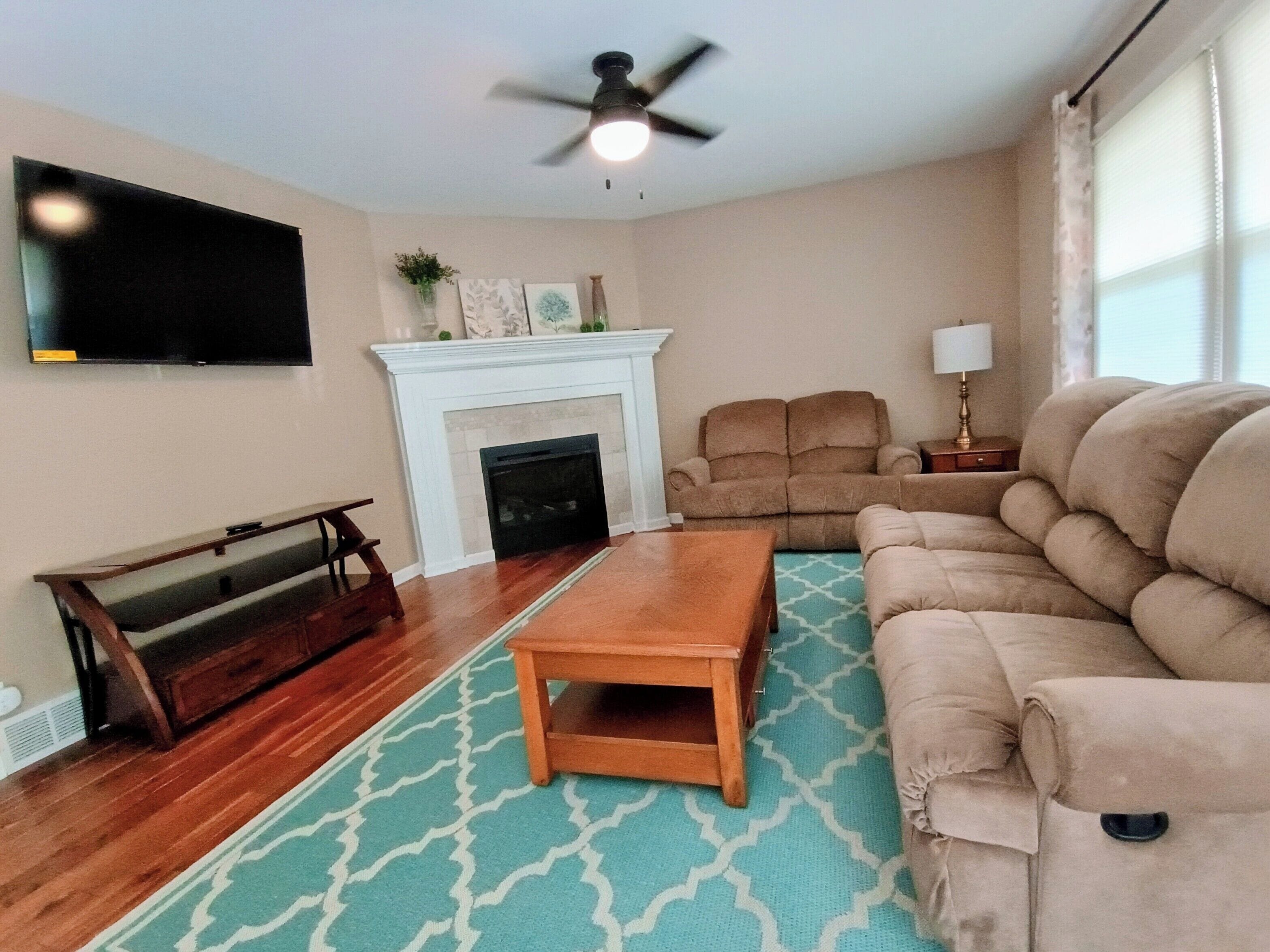 Living Room with reclining sofa and loveseat, coffee table top raises for dining