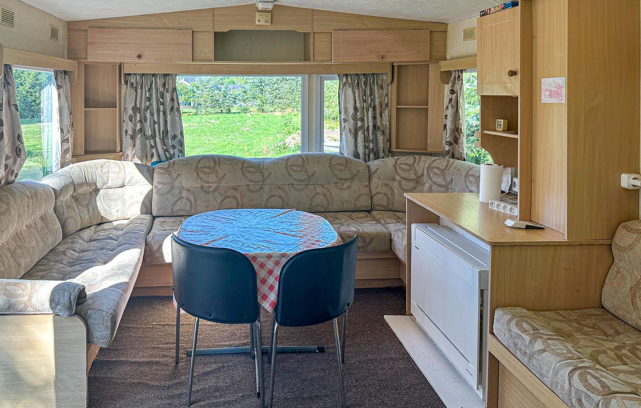 A cozy RV interior with a dining area, sofa, and kitchenette.