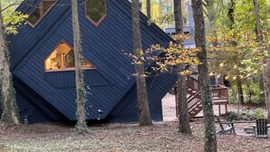 Eine Hütte mit einem einzigartigen, diamantförmigen Design, eingebettet in einen Wald.