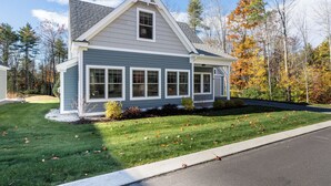 A two-story house with a gabled roof, a covered front porch, and a well-maintained lawn. - Resort style community, heated pools, club house, game room, 15 mins to beaches. (Arundel)