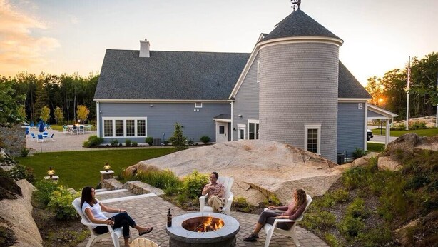 A house with a circular tower, a fire pit, and outdoor seating. - Resort style community, heated pools, club house, game room, 15 mins to beaches. (Arundel)