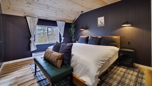 A bedroom with a large bed, a bench, a nightstand, and a window with curtains. - NEW Lodge•HotTub.Game Room.Firepit.Theater.Hammocks (Tobyhanna)