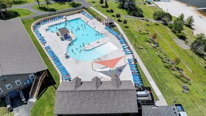 An aerial view of a swimming pool complex with multiple pools, sun loungers, and a small pavilion. - NEW Lodge•HotTub.Game Room.Firepit.Theater.Hammocks (Tobyhanna)