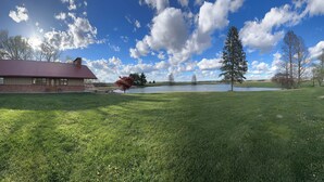A grassy area with a building and a lake. - Family Friendly Lakehouse with great views! (Jasper)