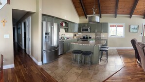 A spacious kitchen with a large island, stainless steel appliances, and a wooden ceiling. - Family Friendly Lakehouse with great views! (Jasper)