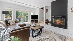 A modern living room with a fireplace, a sofa set, a coffee table, and a television. - Modern 3 Bed / 3 Bath Townhome in Vail with Private Garage - Pets Welcome! (Vail)