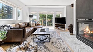 A modern living room with a fireplace, leather sofa, and a television. - Modern 3 Bed / 3 Bath Townhome in Vail with Private Garage - Pets Welcome! (Vail)