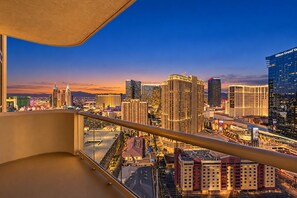 A high-rise hotel with a view of a cityscape at dusk, featuring prominent buildings and a clear sky. - MGM Signature Suite • Full Kitchen • Strip View • Balcony • Pools • Gyms (Las Vegas)