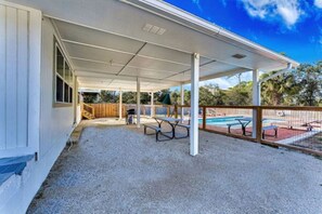 A covered outdoor area with a pool, picnic tables, and a barbecue grill. - Quads-For-Fun, Unit 3,  Saint George Island, FL (Eastpoint)