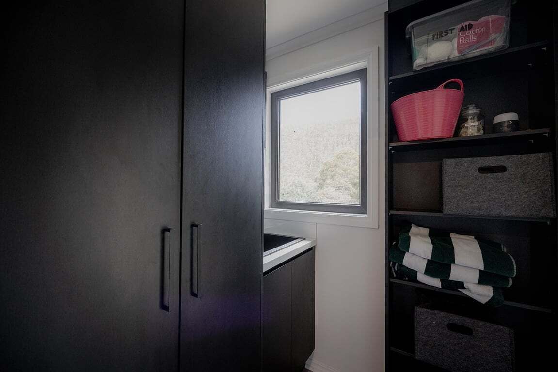 A compact storage unit with shelves, a window, and a small window sill.