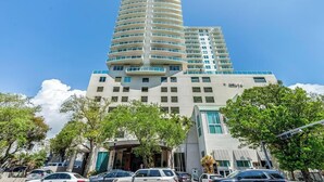 Ein mehrstöckiges Hotel mit modernem Design, das durch eine markante, geschwungene Fassade und viele Balkone gekennzeichnet ist.