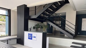 Ein moderner Empfangsbereich mit Treppe, Empfangstresen und Sitzbank.