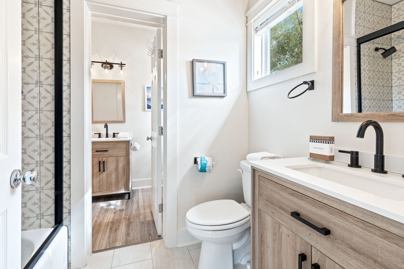 A modern bathroom with a toilet, sink, and vanity.
