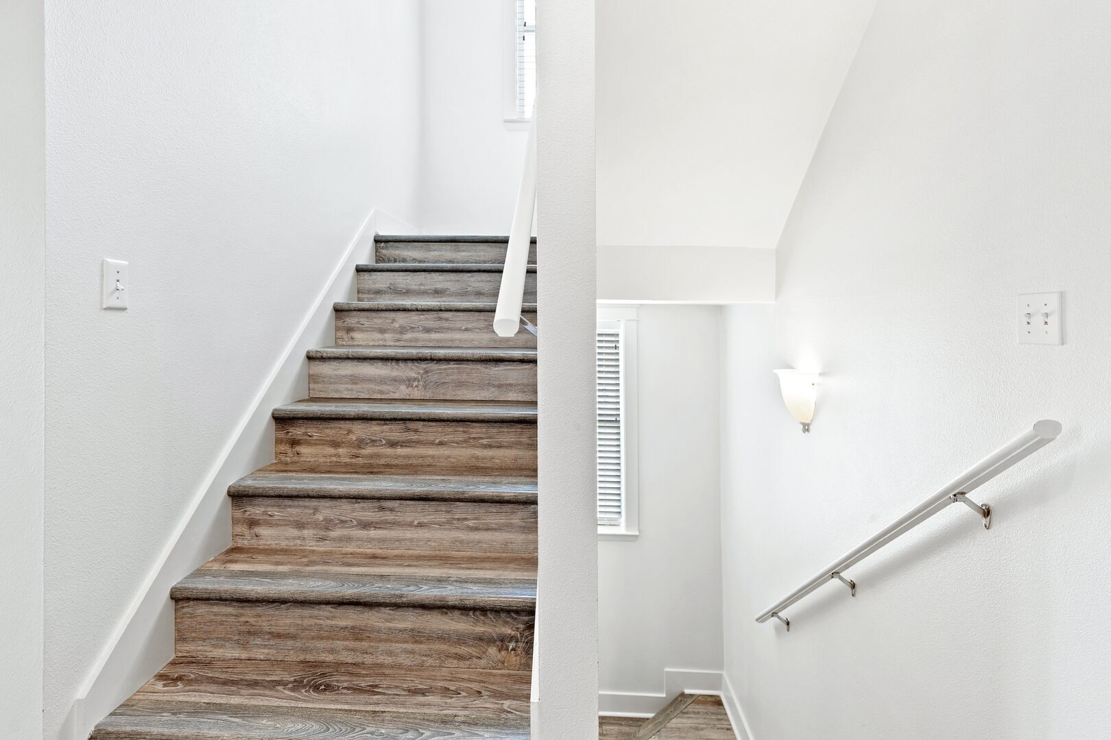 A staircase with wooden steps and white walls.