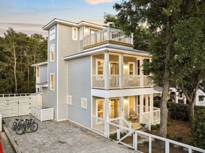 A two-story house with a balcony, a covered porch, and a fenced yard.